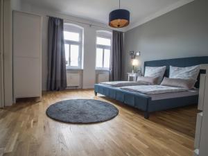 a bedroom with a blue bed and a rug at Stadtbleibe Naumburg in Naumburg