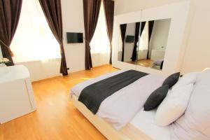 una camera da letto con un grande letto e un grande specchio di Luxury apartments Krocínova a Praga