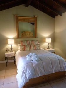 ein Schlafzimmer mit einem großen Bett mit Handtüchern darauf in der Unterkunft Clos Benoit, A Vineyard Inn in El Porvenir