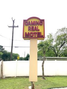 a sign for a gaming real motel on a pole at Camino Real Motel in San Antonio
