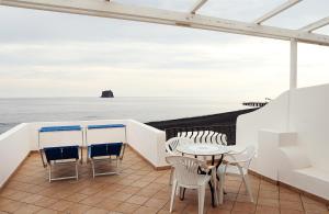 a balcony with a table and chairs and the ocean at La Sirenetta Park Hotel in Stromboli