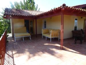 eine Terrasse mit 2 Stühlen und einem Sonnenschirm in der Unterkunft Clos Benoit, A Vineyard Inn in El Porvenir