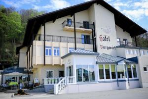 - un grand bâtiment blanc avec un panneau dans l'établissement Hotel Burgwirt, à Deggendorf