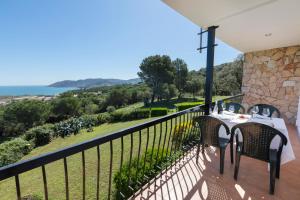 balcón con mesa, sillas y vistas al océano en Apartament Cap de Vol, en Port de la Selva