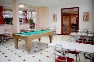 a pool table in a room with tables and chairs at Hotel Plaza Sul in Caràzinho