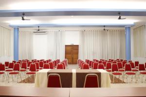 a conference room with a table and red chairs at Hotel Plaza Sul in Caràzinho