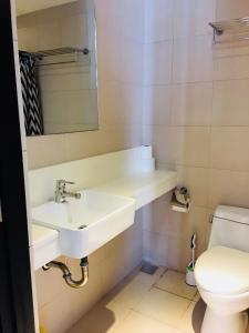a bathroom with a sink and a toilet at Portovita Towers in Manila