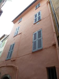 a pink building with blue shutters on it at Karolina Properties - Misericorde Appartements in Cannes