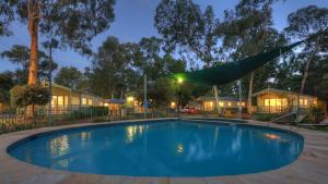 a swimming pool in a yard at night at Crystal Brook Tourist Park in Doncaster East