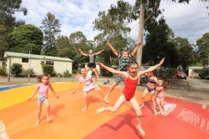 a group of children jumping on a trampoline at Crystal Brook Tourist Park in Doncaster East