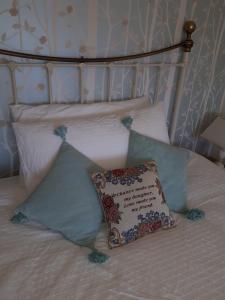 a pillow sitting on top of a bed with pillows at Court Barn Cottage B&B in Burwash