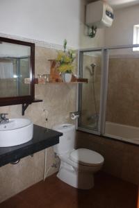 y baño con aseo, lavabo y ducha. en Maison Vu Tri Vien en Hue