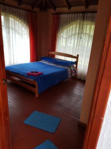 a bedroom with a bed and two windows at Finca Villa Patricia in Paipa