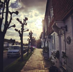een straat met auto's aan de zijkant van een gebouw bij Court Barn Cottage B&B in Burwash