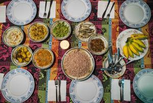 una mesa con platos y tazones de comida. en Peak House, en Hiriketiya