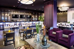restauracja z purpurowymi krzesłami i stołami oraz bar w obiekcie Hyatt House Charlotte Center City w mieście Charlotte