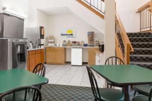 una cucina con tavoli e sedie verdi in una stanza di Days Inn by Wyndham Concordia a Concordia