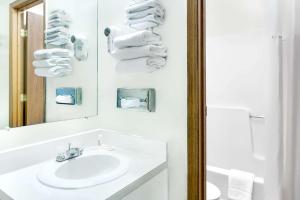 a bathroom with a sink and a mirror and towels at Days Inn by Wyndham Concordia in Concordia +8 photos