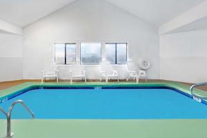 a swimming pool in a room with white chairs at Days Inn by Wyndham Concordia in Concordia