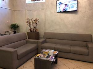 salon z kanapą i telewizorem w obiekcie Hotel Brenta Milano w Mediolanie