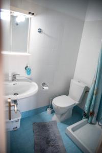 y baño con aseo blanco y lavamanos. en Zoumboulis Rooms, en Mytilini