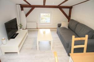ein Wohnzimmer mit einem Sofa und einem Tisch in der Unterkunft Gemütliche Dachgeschoßwohnung mit Altbaucharme in Lübeck