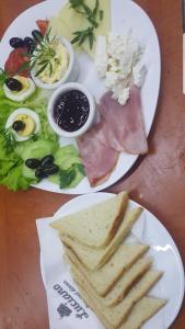 ヴァルナ・シティにあるCathedral Guesthouseのサンドイッチとディップを含む2皿の食べ物が付いたテーブル