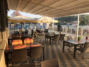 un patio esterno con tavoli, sedie e ombrelloni di Hotel Rhein INN a Remagen