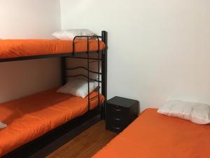 2 literas en una habitación con cama naranja en Casa hotel Sports and Family, en Bogotá