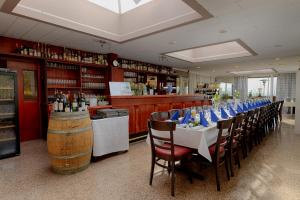 a restaurant with a long table with chairs and a bar at Hotel Restaurant Litermont in Nalbach