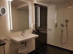 a bathroom with a sink and a shower with a mirror at Hotel Restaurant Alte Stadtmauer in Beilstein +77 photos