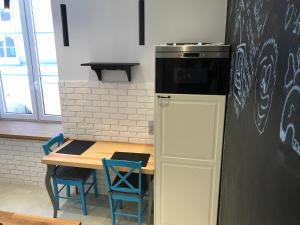 uma cozinha com uma mesa e um frigorífico preto em Apartament Na Piwnej em Gdańsk