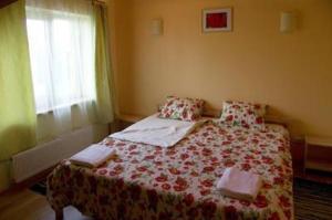 a bedroom with a bed with a red and white blanket at Guest House Magones in Preiļi