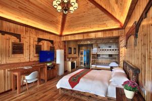 een slaapkamer met een groot bed en een houten plafond bij Baike Boutique Hotel in Longsheng