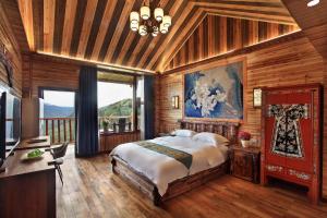 龙胜Baike Boutique Hotel的一间带大床的卧室和一个阳台