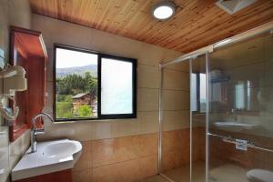 een badkamer met een wastafel, een douche en een raam bij Baike Boutique Hotel in Longsheng +37 foto's