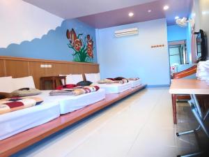 a room with four beds in it with a wall with a mural at Nan Wan KiKi Guesthouse in Nanwan