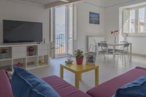 a living room with a tv and a table with a couch at Hello Gaeta Apartment in Gaeta