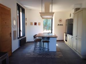 a kitchen with a table and some stools in it at La Mésange in Millau