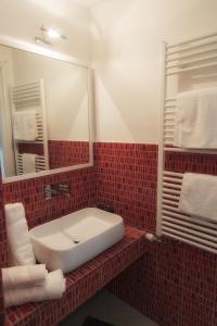 a red tiled bathroom with a sink and a mirror at Hello Gaeta Apartment in Gaeta +17 photos