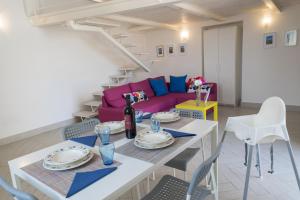 a living room with a table and a purple couch at Hello Gaeta Apartment in Gaeta