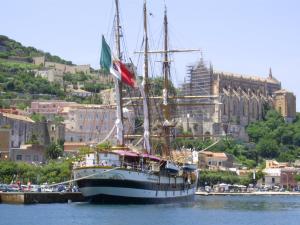 a large boat sitting in the water near a city at I due mari in Gaeta
