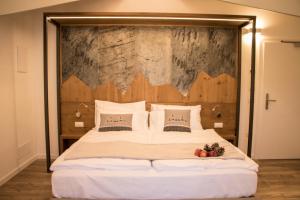 a bedroom with a large bed with a wooden headboard at Hotel Florida in Levico Terme