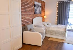 um quarto com uma cama e uma parede de tijolos em Apartamenty Bryza - Ulanska - Parking em Świnoujście