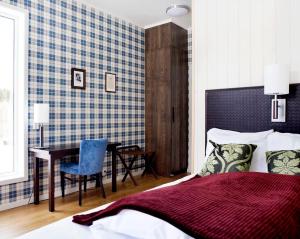 a bedroom with a bed and a table and a desk at Søstrene Storaas hotell in Bolkesjø