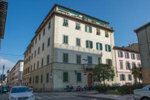 a tall white building with green shutters on a street at Affittacamere Benedetta in Florence