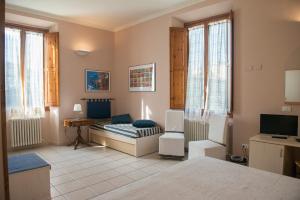 a bedroom with a bed and a desk and a television at Affittacamere Benedetta in Florence