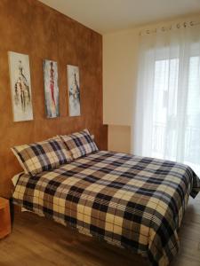 a bedroom with a bed with a plaid blanket at DAMALU' in Conversano