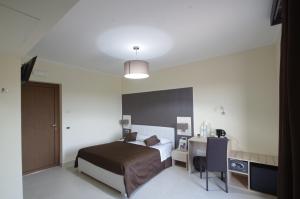 Habitación de hotel con cama, escritorio y cama en B&B Villa Valentina, en Taormina