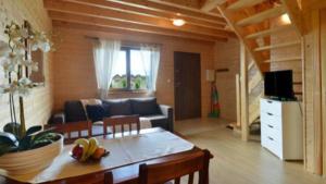 a living room with a couch and a table at Bursztynowe Domki in Sarbinowo